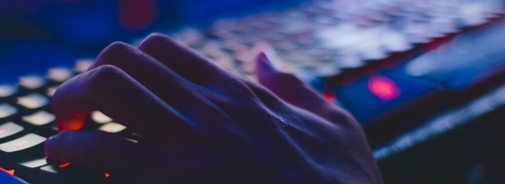 hands on a computer keyboard in the dark