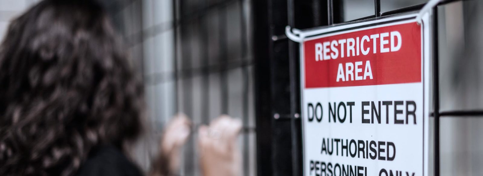 person trespassing near a sign marking the area restricted