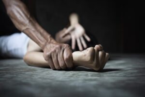 Man's hand holding a woman hand, sexual abuse and rape concept.