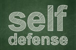 Text Self Defense on Green chalkboard background
