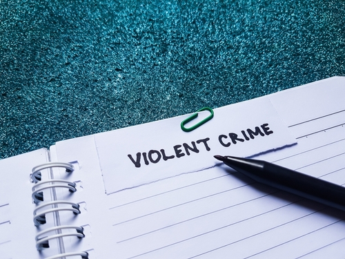A notebook labeled “violent crime” with a pen resting on the page, representing cases handled with the support of a Houston criminal lawyer.