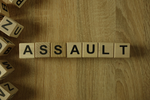 Aggravated assault attorney in Houston image showing the word “assault” spelled with wooden letter blocks on a table.